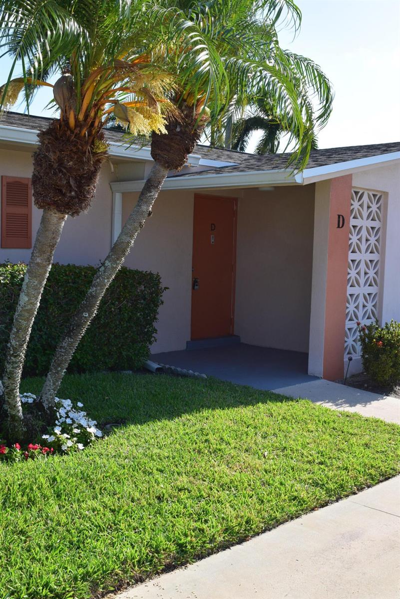 A palm tree stands in front of a building entrance marked with the letter D — 2747 E Dudley Dr Drive E # D, West Palm Beach FL 33415, WEST PALM BEACH, FL