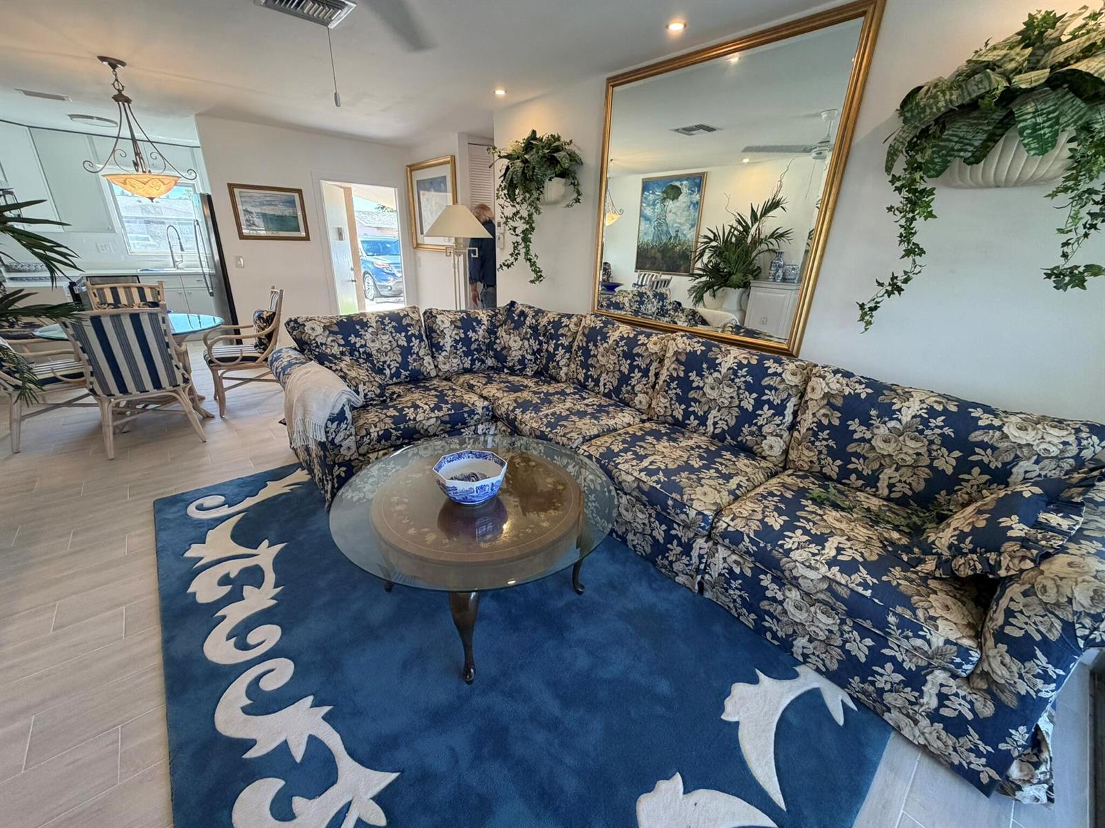 A living room features a large floral sectional sofa, a glass coffee table, and a rug — 2747 E Dudley Dr Drive E # D, West Palm Beach FL 33415, WEST PALM BEACH, FL