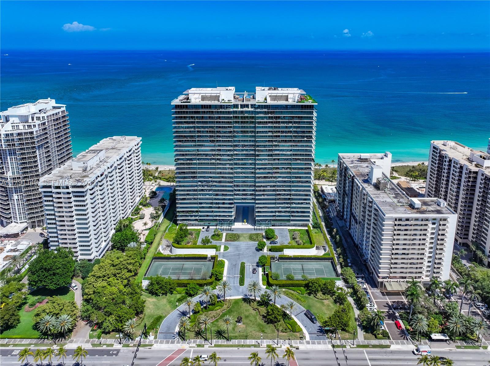 An aerial view shows a tall residential building surrounded by tennis courts and lush landscaping — 10201 Collins Ave # 605, Bal Harbour FL 33154, BAL HARBOUR, FL