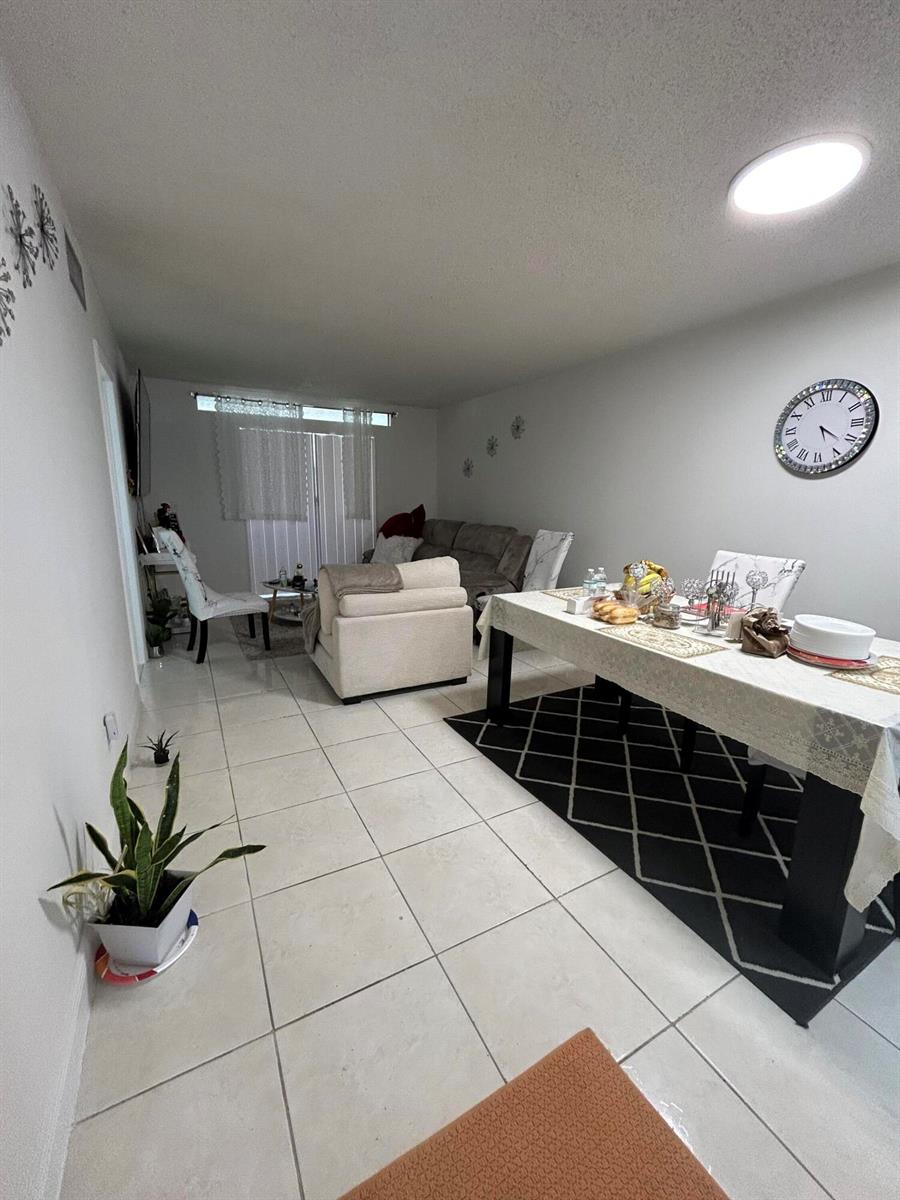 A living and dining area features white tile floors, a dining table, and a sofa — 6600 Royal Palm Boulevard # 103b, Margate FL 33063, MARGATE, FL