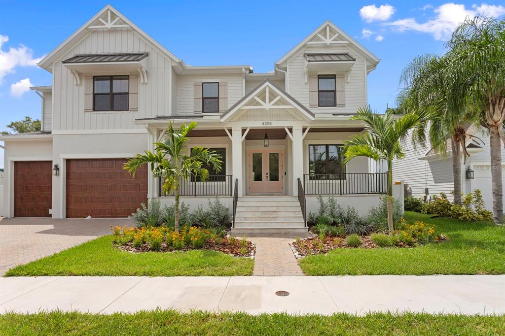 A two-story house with white siding, a covered front porch, and a two-car garage — 4208 W VASCONIA STREET, TAMPA, FL