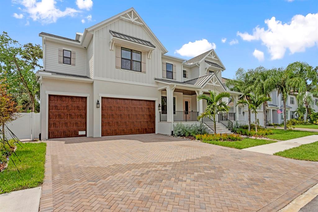A two-story house with a paved driveway, three-car garage, and a covered front porch — 4208 W VASCONIA STREET, TAMPA, FL