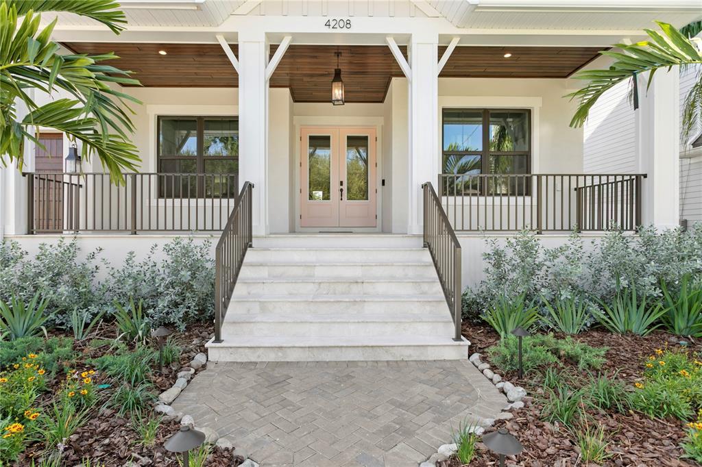 A front porch with white columns, light pink double doors, and stone steps — 4208 W VASCONIA STREET, TAMPA, FL