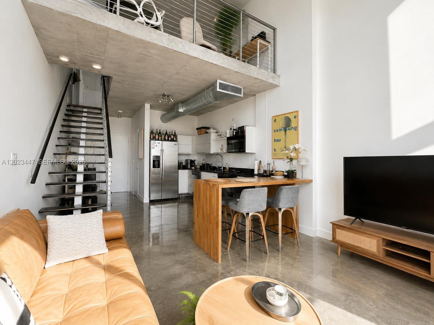 A modern loft apartment features a kitchen, living area, concrete ceiling, and a metal staircase — 690 SW 1st Ct # 2314, Miami FL 33130, MIAMI, FL