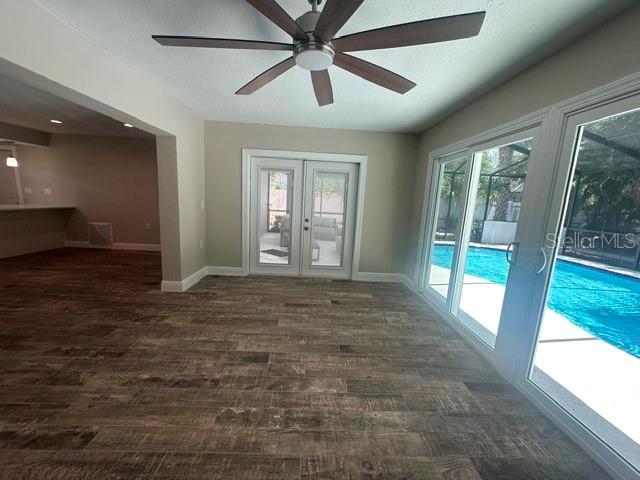 A living area features wood-look tile flooring, a ceiling fan, and sliding doors to a pool — 103 CARLYLE DRIVE, PALM HARBOR, FL
