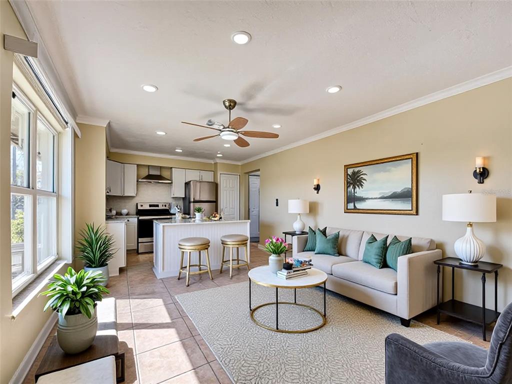 An open-concept living room and kitchen featuring tile floors, a sofa, and a breakfast island — 21150 GERTRUDE AVENUE UNIT G3, PORT CHARLOTTE, FL