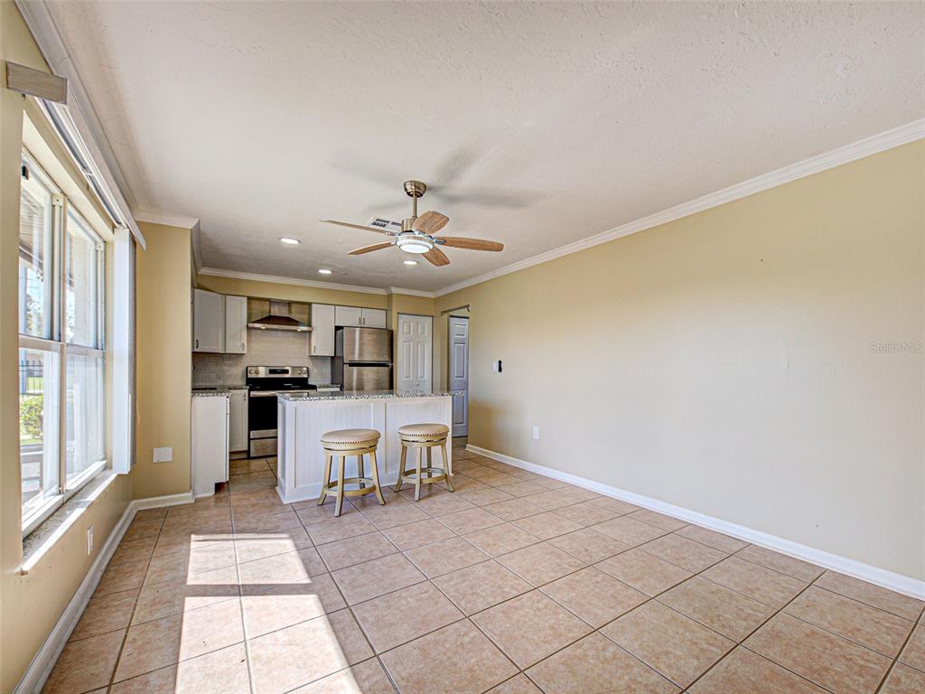 A kitchen with a center island, two bar stools, and tile flooring — 21150 GERTRUDE AVENUE UNIT G3, PORT CHARLOTTE, FL