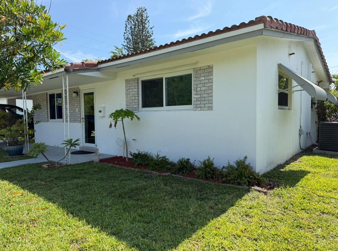 A white single-story house with a tiled roof, brick accents, and a front lawn — 206 NE 5th Avenue, Dania Beach FL 33004, DANIA BEACH, FL
