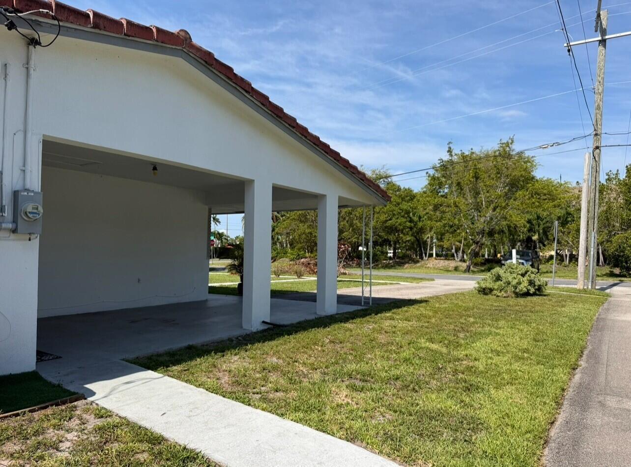 A white house exterior features a covered carport with concrete pillars and a tiled roof — 206 NE 5th Avenue, Dania Beach FL 33004, DANIA BEACH, FL