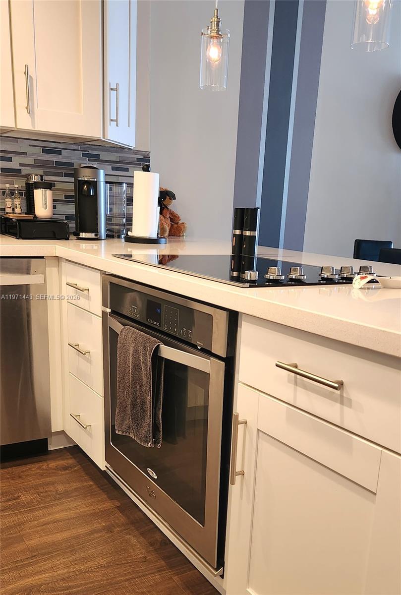 A modern kitchen features white cabinets, stainless steel appliances, and a glass cooktop — 1000 Parkview Dr # 1026, Hallandale Beach FL 33009, HALLANDALE BEACH, FL