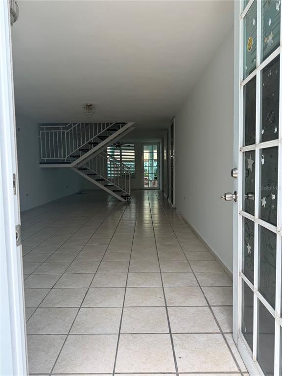 An open-concept living area features light tile flooring and a staircase leading to the upper level — 0 BESO DE MAR UNIT A13, CAROLINA, PR