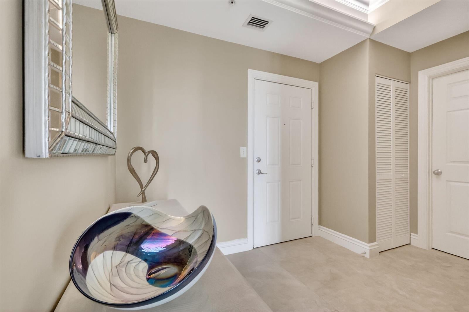 A hallway features a mirrored console table, a decorative heart sculpture, and a wall mirror — 700 E Boynton Beach Boulevard # 2, Boynton Beach FL 33435, BOYNTON BEACH, FL