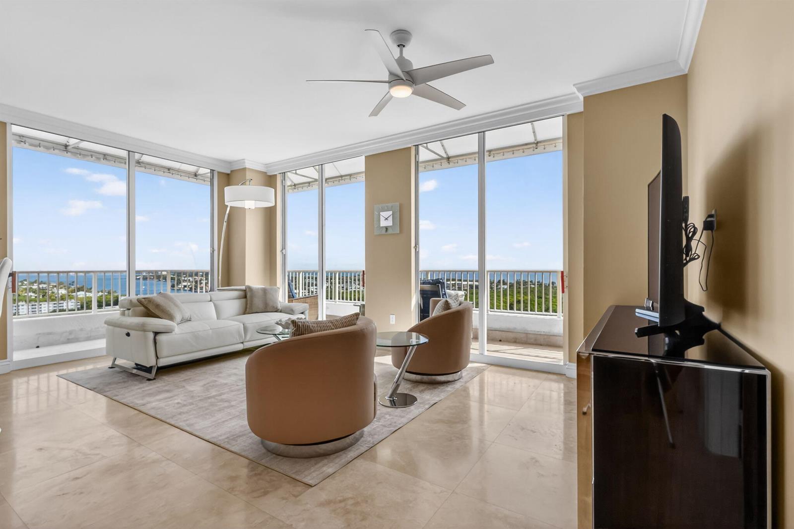 A dining area with a glass table and chairs sits before a bright, open living room — 700 E Boynton Beach Boulevard # 2, Boynton Beach FL 33435, BOYNTON BEACH, FL