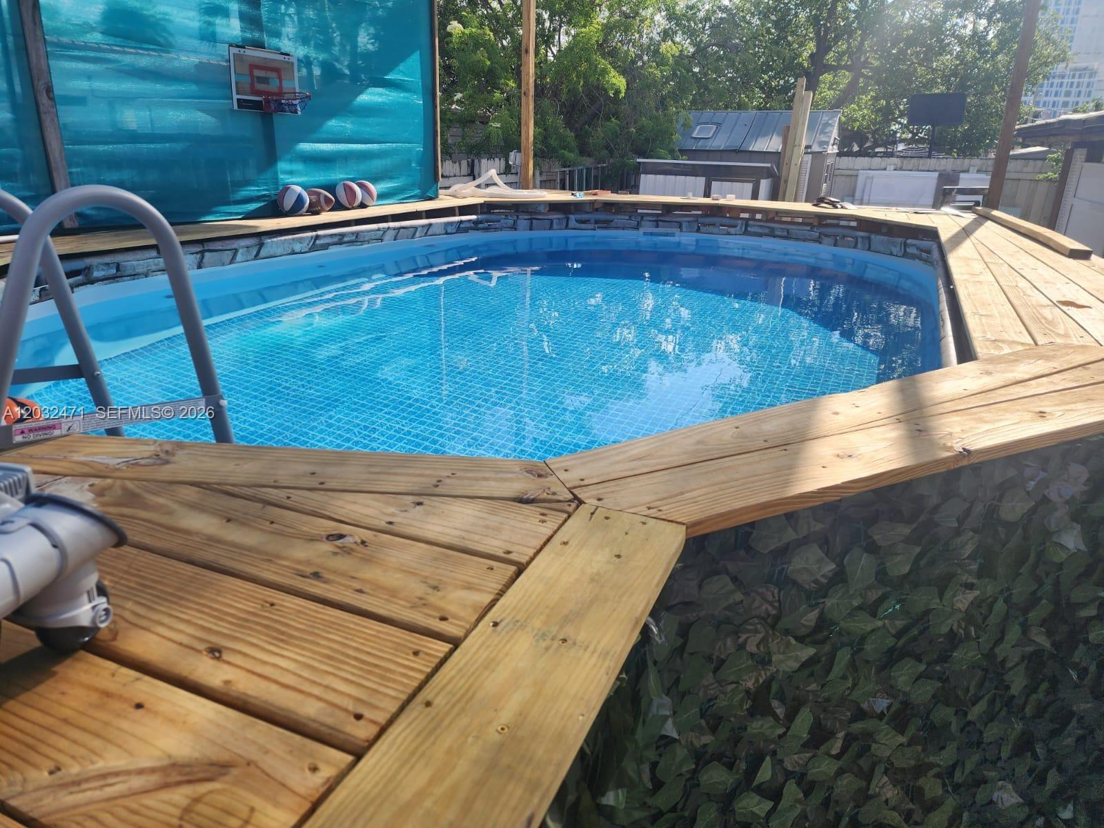 An above-ground swimming pool is surrounded by a wooden deck and a privacy screen — 11267 SW 7th St, Sweetwater FL 33174, SWEETWATER, FL