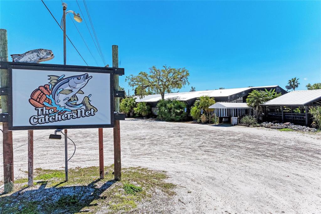 A sign for The Catcher's Net stands in front of a large, low-slung commercial building — 5611 US HIGHWAY 19, PALMETTO, FL