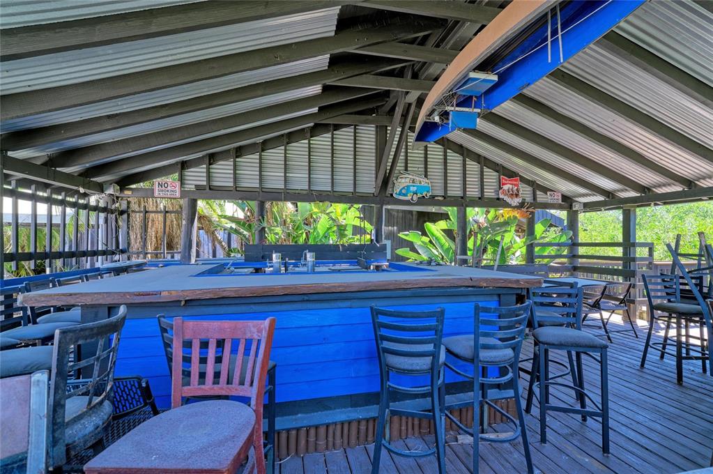 An outdoor covered bar area features blue wooden paneling, metal roofing, and several bar stools — 5611 US HIGHWAY 19, PALMETTO, FL