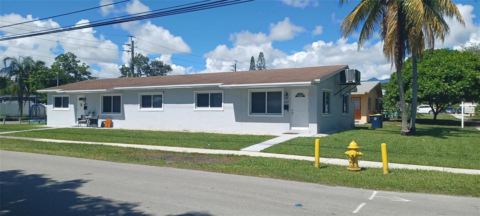 A single-story, light gray house with a brown roof sits on a grassy lot — 602 SE 2nd Avenue, Dania Beach FL 33004, DANIA BEACH, FL