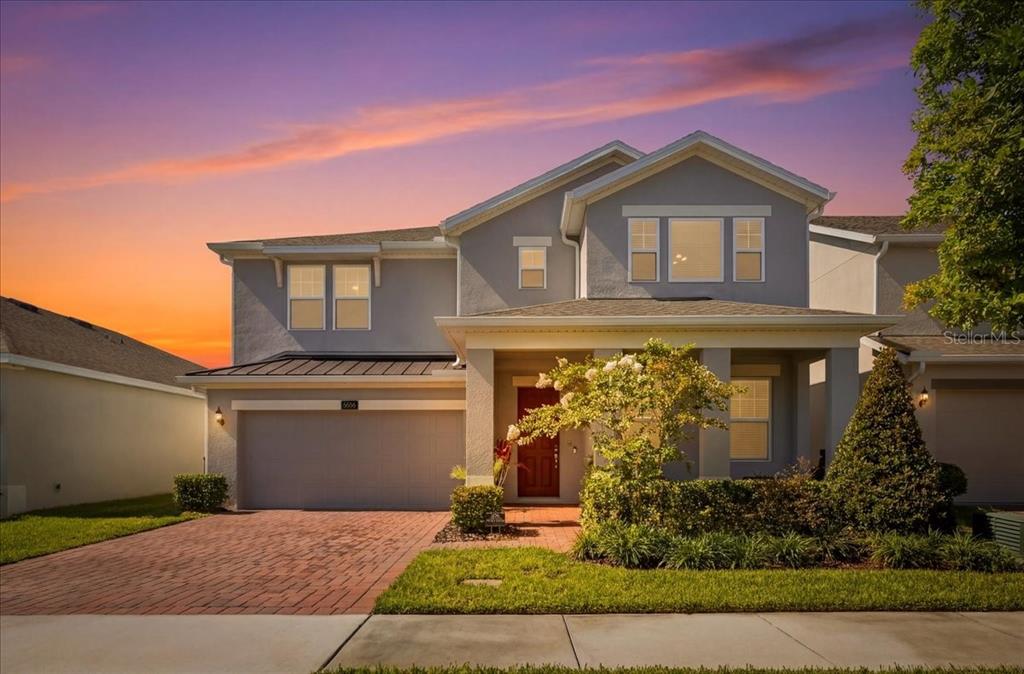 A two-story house with a gray stucco exterior, a red front door, and a brick driveway — 5026 DOWN COURT, ST CLOUD, FL