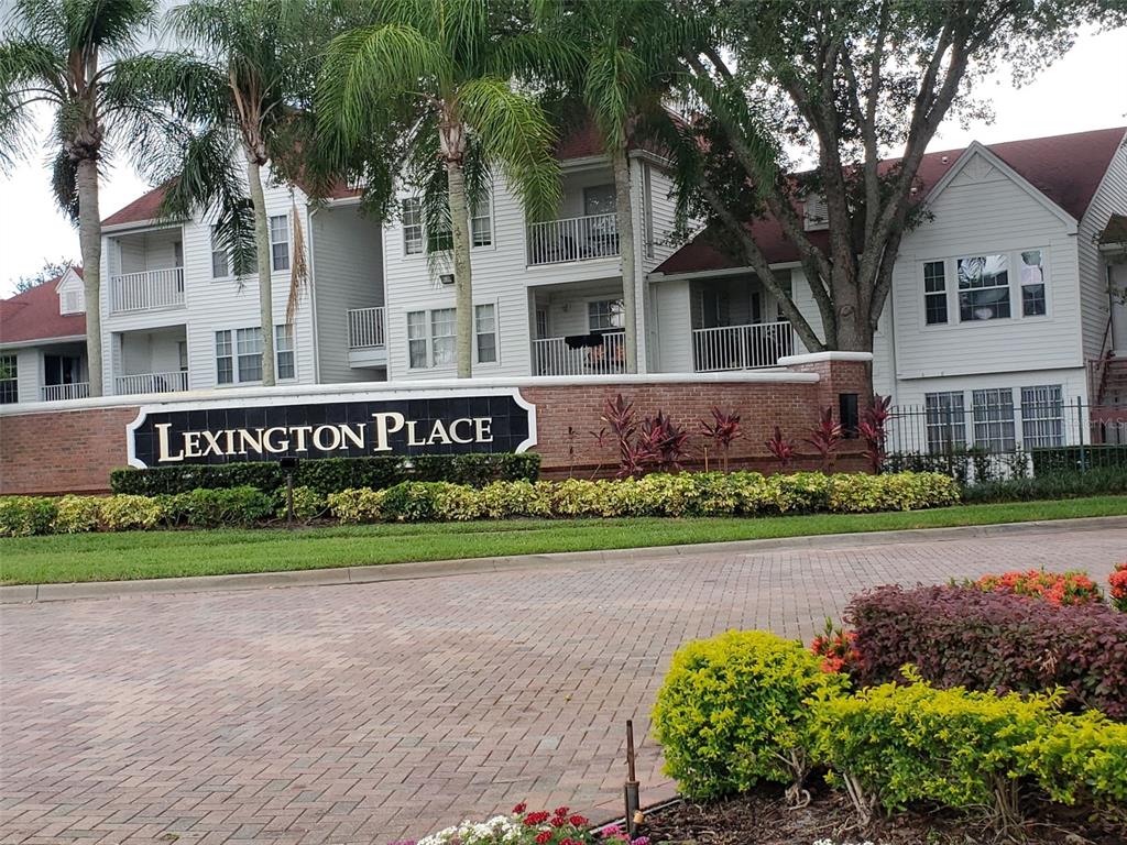 A brick monument sign for Lexington Place stands in front of a multi-story apartment building — 11582 WESTWOOD BOULEVARD UNIT 1436, ORLANDO, FL