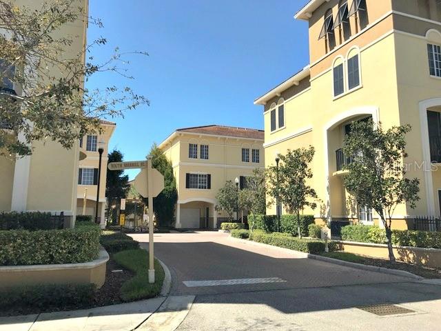 A street view shows multi-story yellow apartment buildings with a street sign in the foreground — 105 S SHERRILL STREET, TAMPA, FL