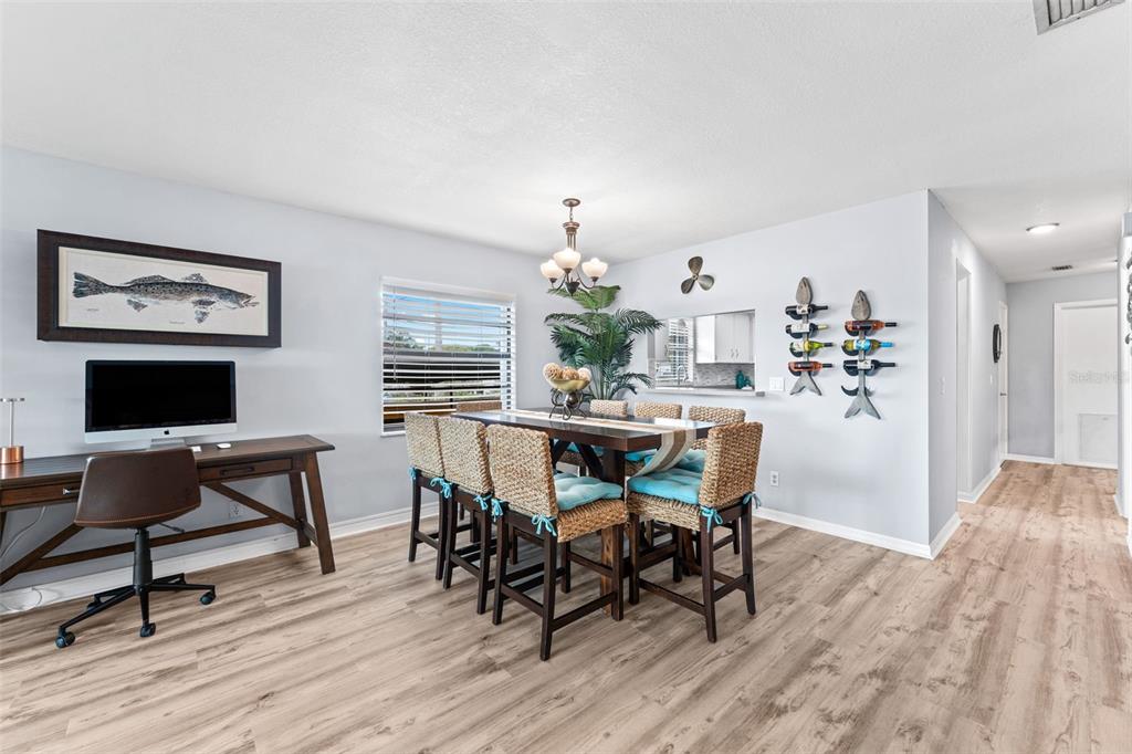 A dining area with a wooden table, woven chairs, and a desk against the wall — 29 PELICAN LANE, EDGEWATER, FL