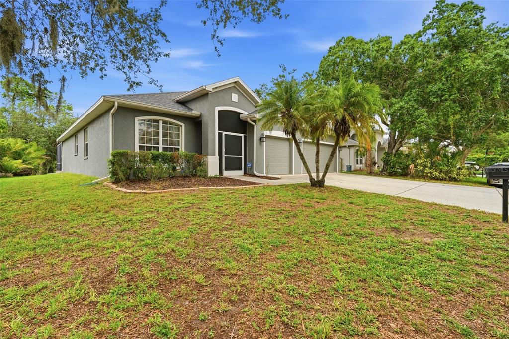 A single-story gray house with a two-car garage and palm trees in the front yard — 835 CEDARCREST COURT, SARASOTA, FL