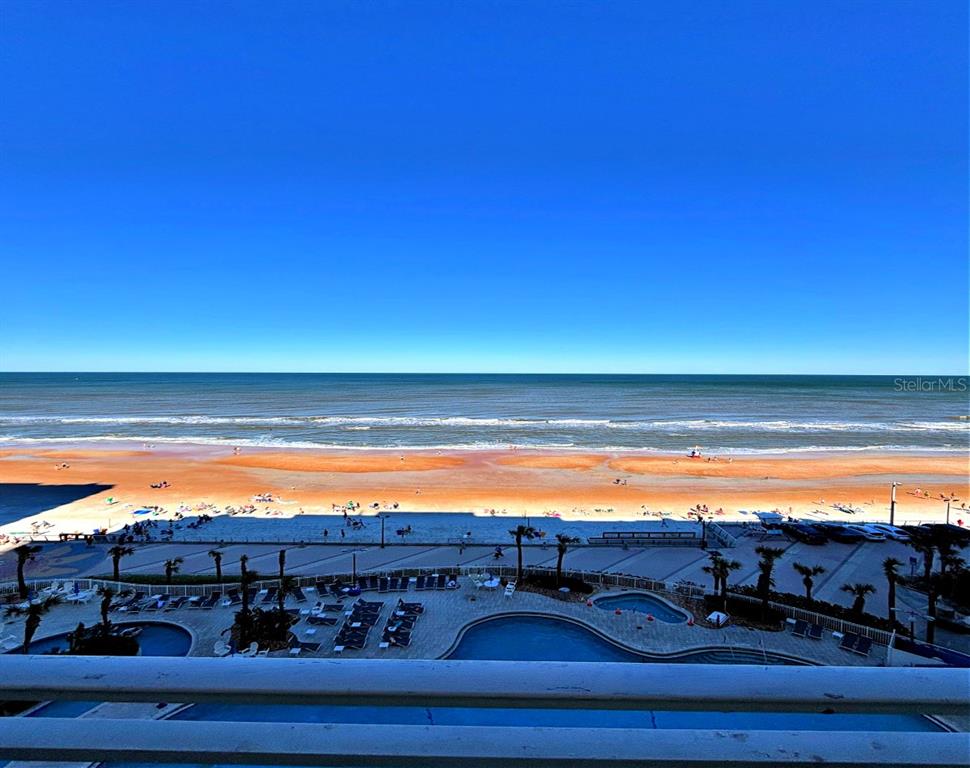 An elevated view of a beach, ocean, and resort pool deck from a balcony — 300 N ATLANTIC AVENUE UNIT 1908, DAYTONA BEACH, FL