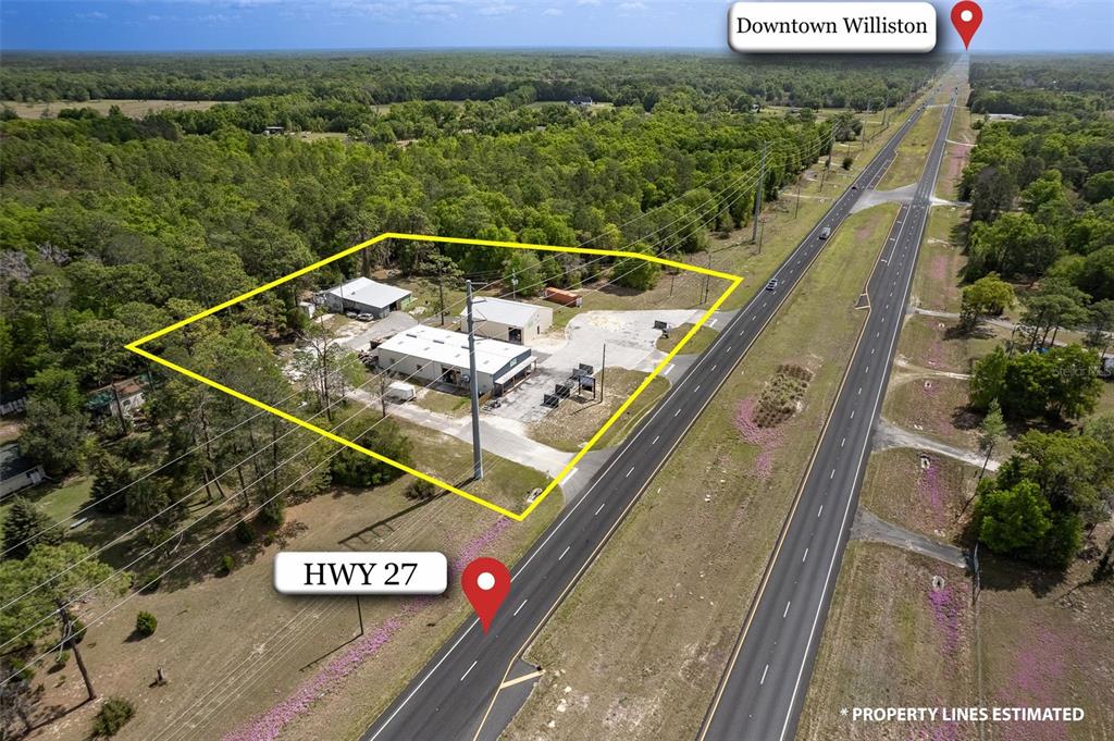 An aerial view shows commercial buildings on a lot adjacent to a highway — 14131 NE HIGHWAY 27 ALT, WILLISTON, FL