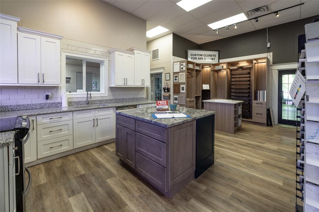 A showroom displays white kitchen cabinets, a gray island, and custom closet storage units — 14131 NE HIGHWAY 27 ALT, WILLISTON, FL