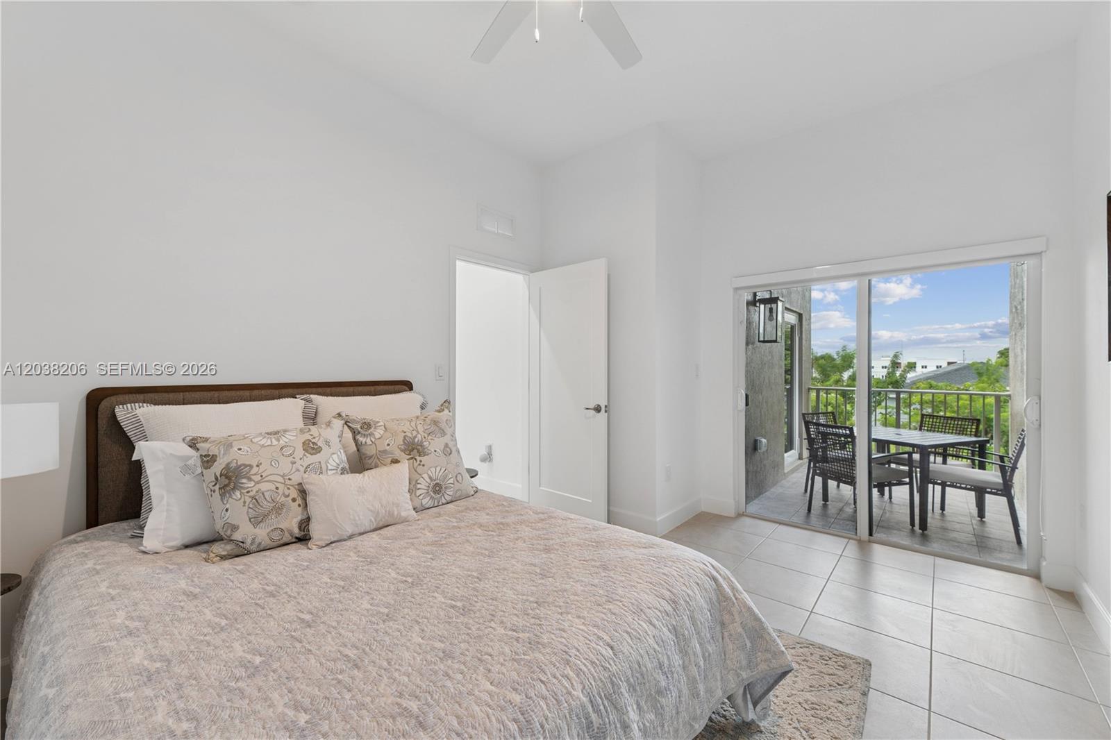A bedroom with a bed, tiled floors, and a sliding glass door leading to a balcony — 635 NW 30 terrace, Pompano Beach FL 33069, POMPANO BEACH, FL