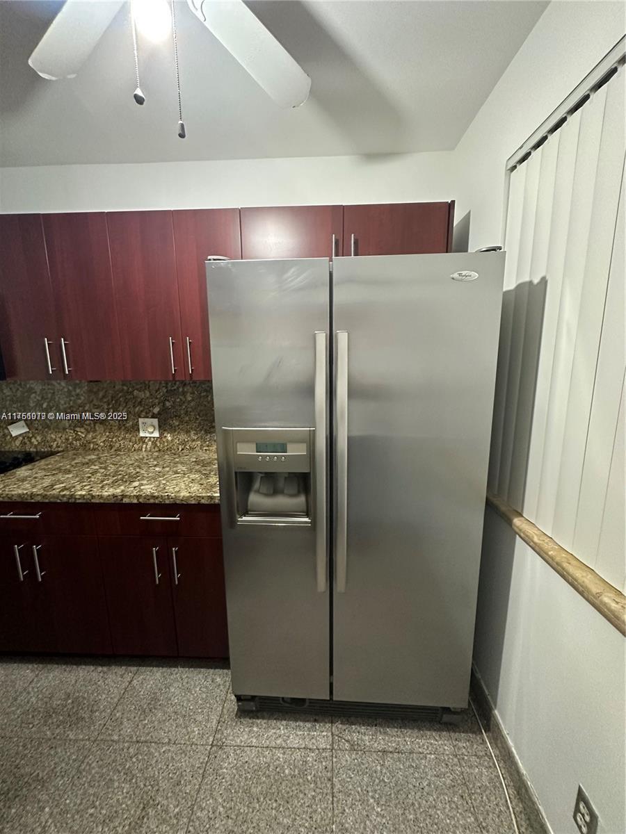 A kitchen features dark wood cabinets, granite countertops, and a stainless steel side-by-side refrigerator — 1100 NE 1st Ct # 105, Hallandale Beach FL 33009, HALLANDALE BEACH, FL