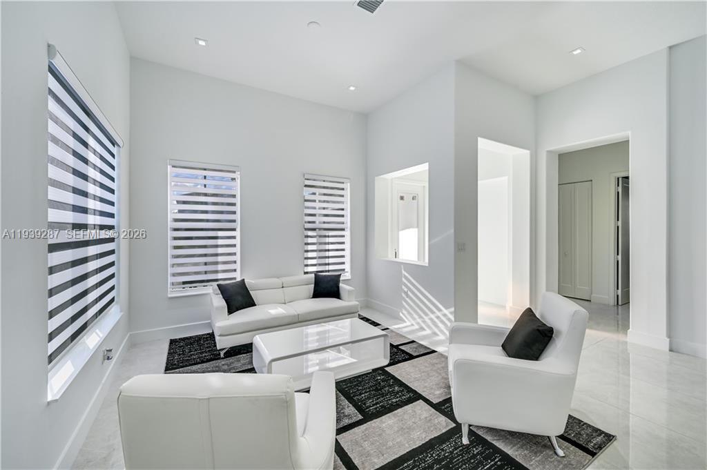 A modern living room features white walls, tile floors, a white sofa, and armchairs — 4919 Frattinas # 4919, Ave Maria FL 34142, AVE MARIA, FL