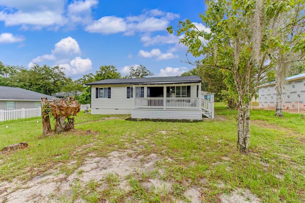 A single-story house with light siding and a front porch sits on a grassy lot — 1450 3RD STREET, ORANGE CITY, FL