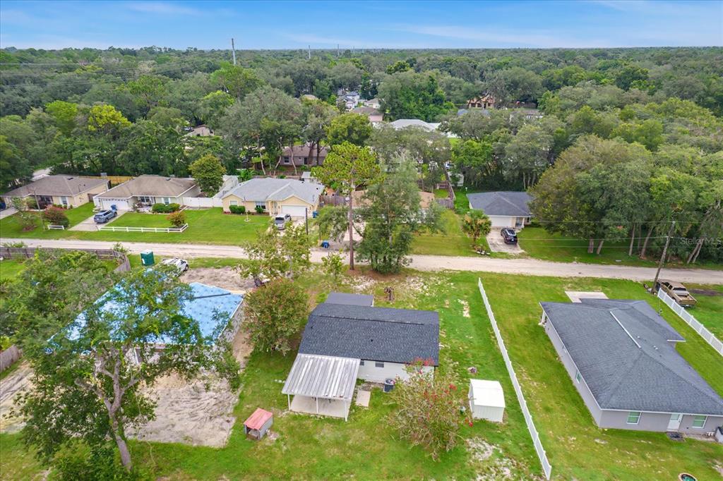 An aerial view shows a residential neighborhood with several houses, green lawns, and mature trees — 1450 3RD STREET, ORANGE CITY, FL