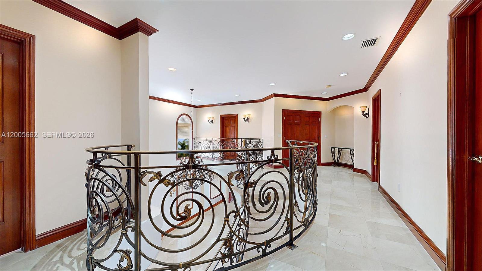 An upstairs hallway features marble floors, ornate metal railings, and dark wood trim — 1131 Stillwater Dr, Miami Beach FL 33141, MIAMI BEACH, FL