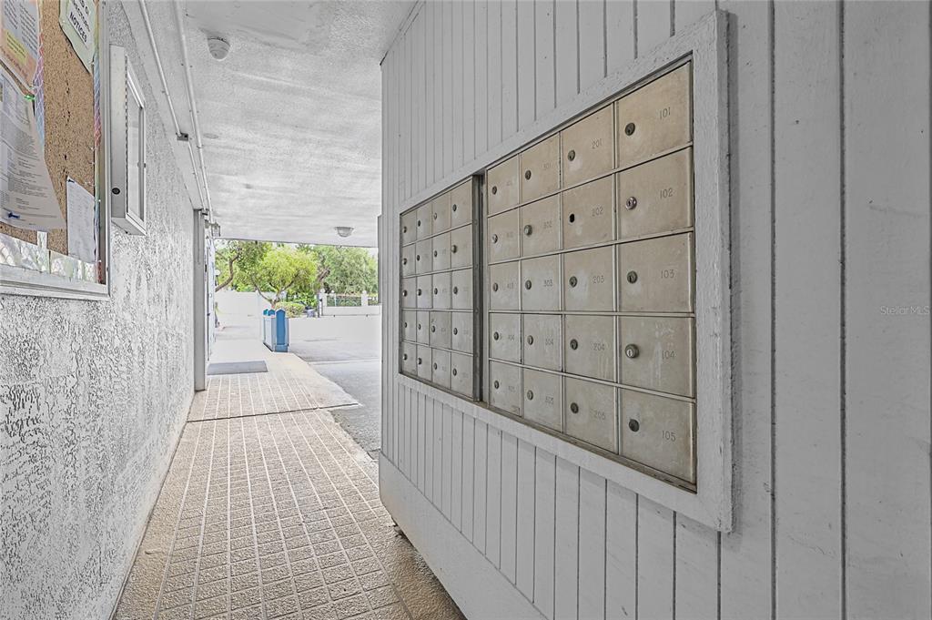 A covered outdoor walkway features a wall of metal mailboxes and a cork bulletin board — 2780 N RIVERSIDE DRIVE UNIT 502, TAMPA, FL