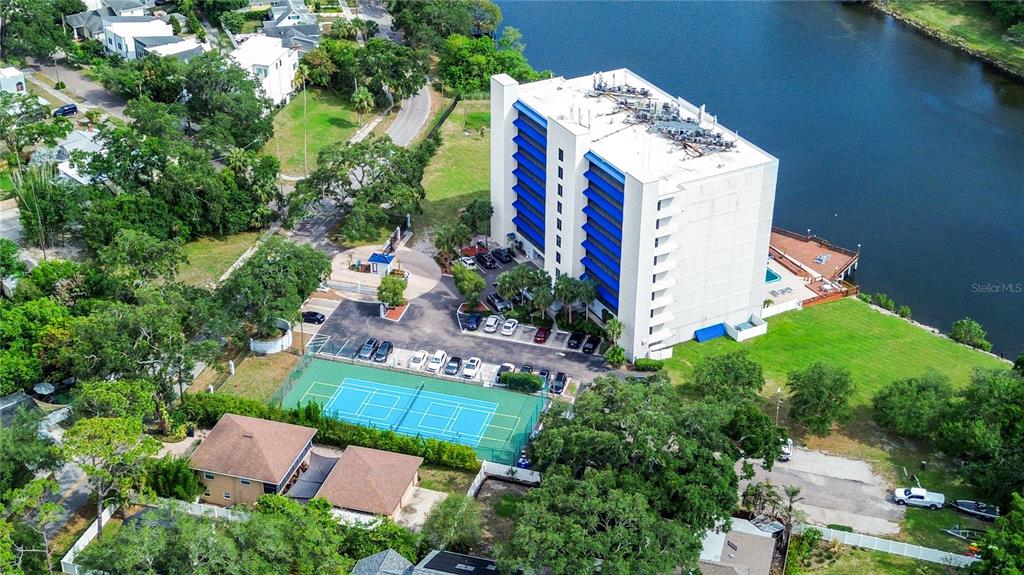 An aerial view shows a multi-story apartment building, a tennis court, and a parking lot — 2780 N RIVERSIDE DRIVE UNIT 502, TAMPA, FL