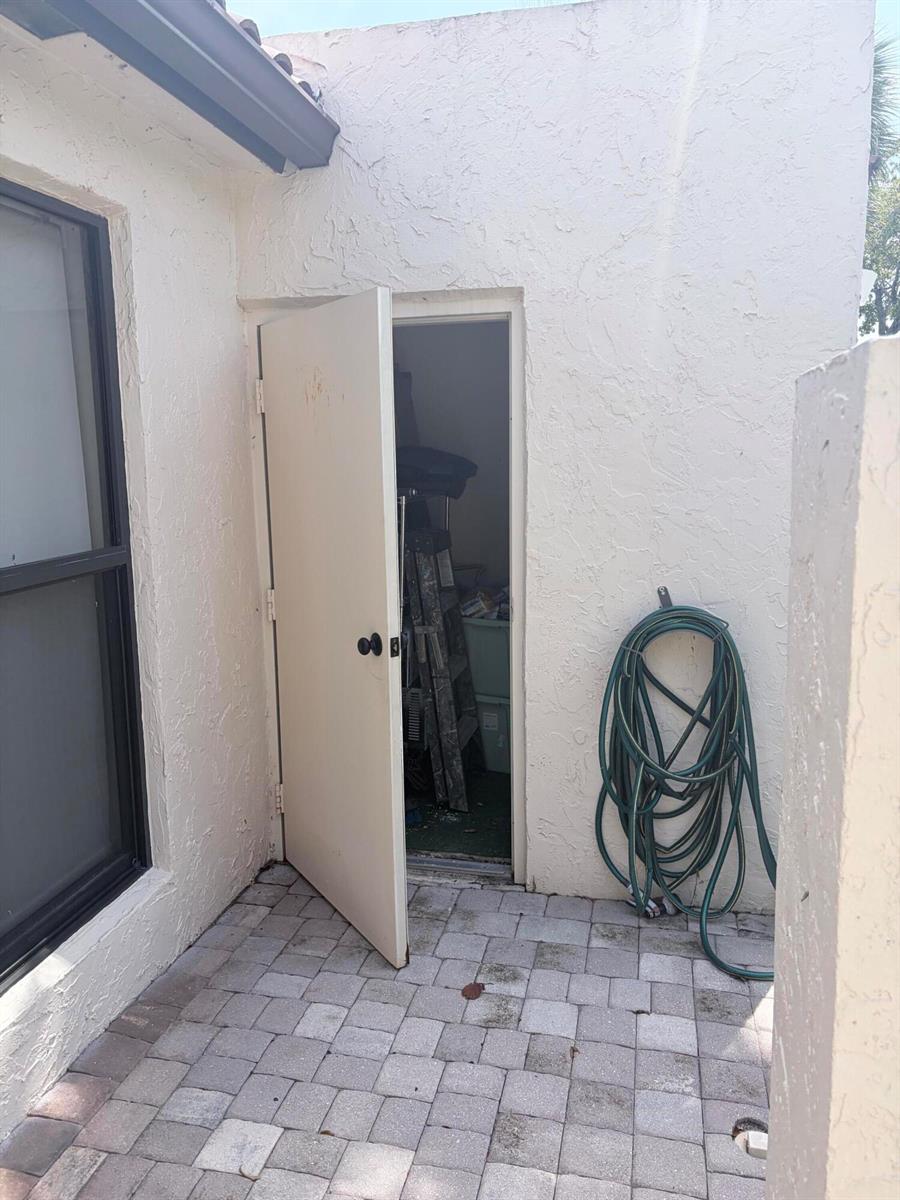 An open door leads to a small storage closet on a paved outdoor patio — 3072 Inglewood Terrace, Boca Raton FL 33431, BOCA RATON, FL
