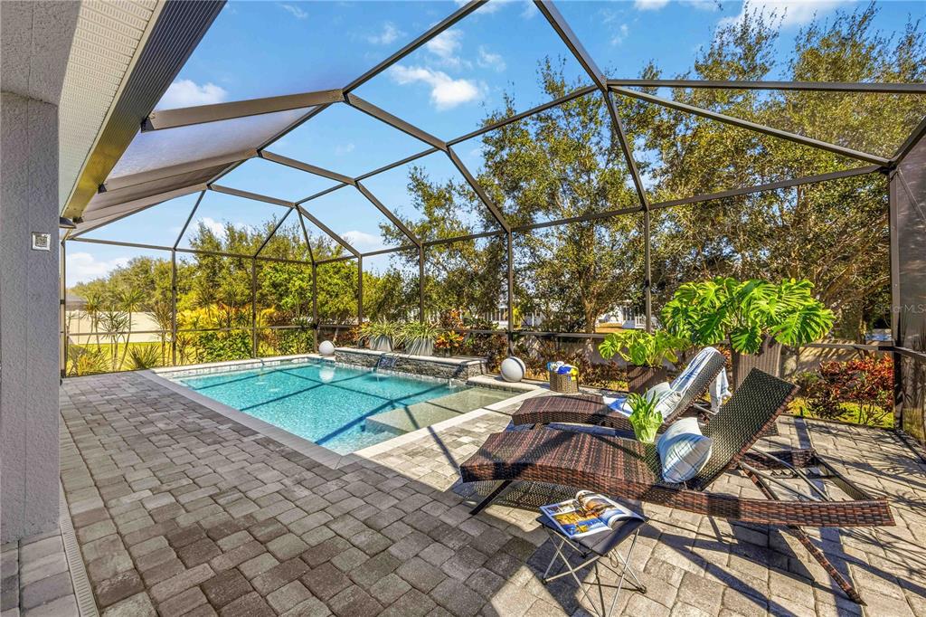 A single-story house with a blue garage door, palm trees, and a concrete driveway — 5731 ARBOR WOOD COURT, BRADENTON, FL