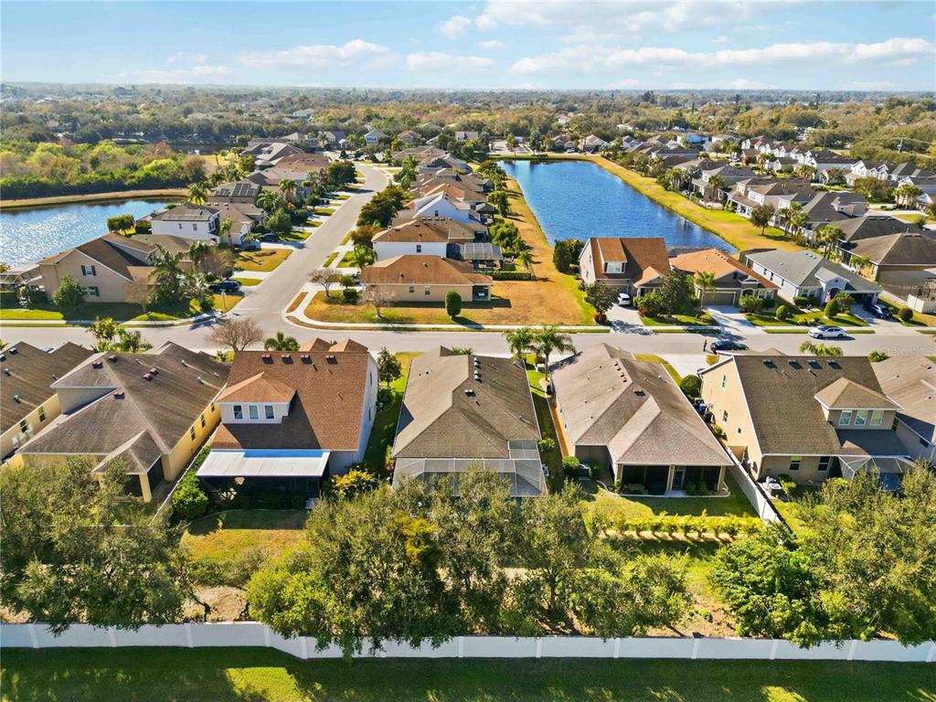 A covered patio features a seating area, outdoor kitchen, and a screened-in swimming pool — 5731 ARBOR WOOD COURT, BRADENTON, FL