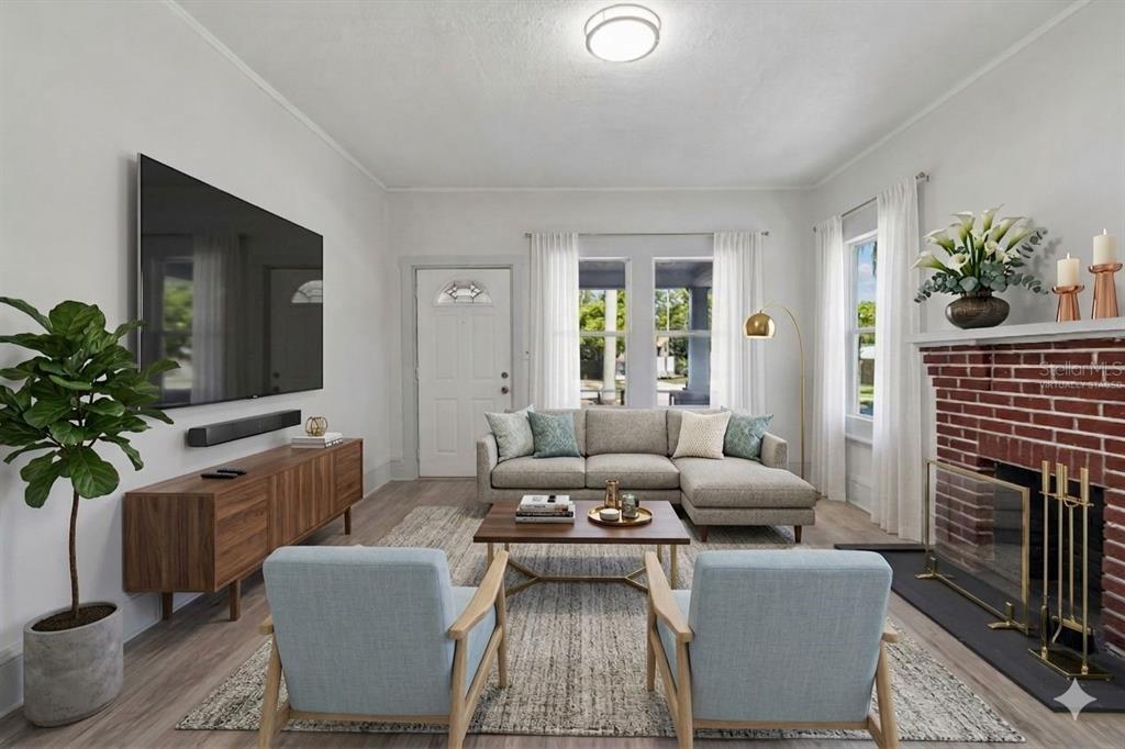 A living room features a brick fireplace, a sectional sofa, and two light blue chairs — 1002 23RD STREET W, BRADENTON, FL