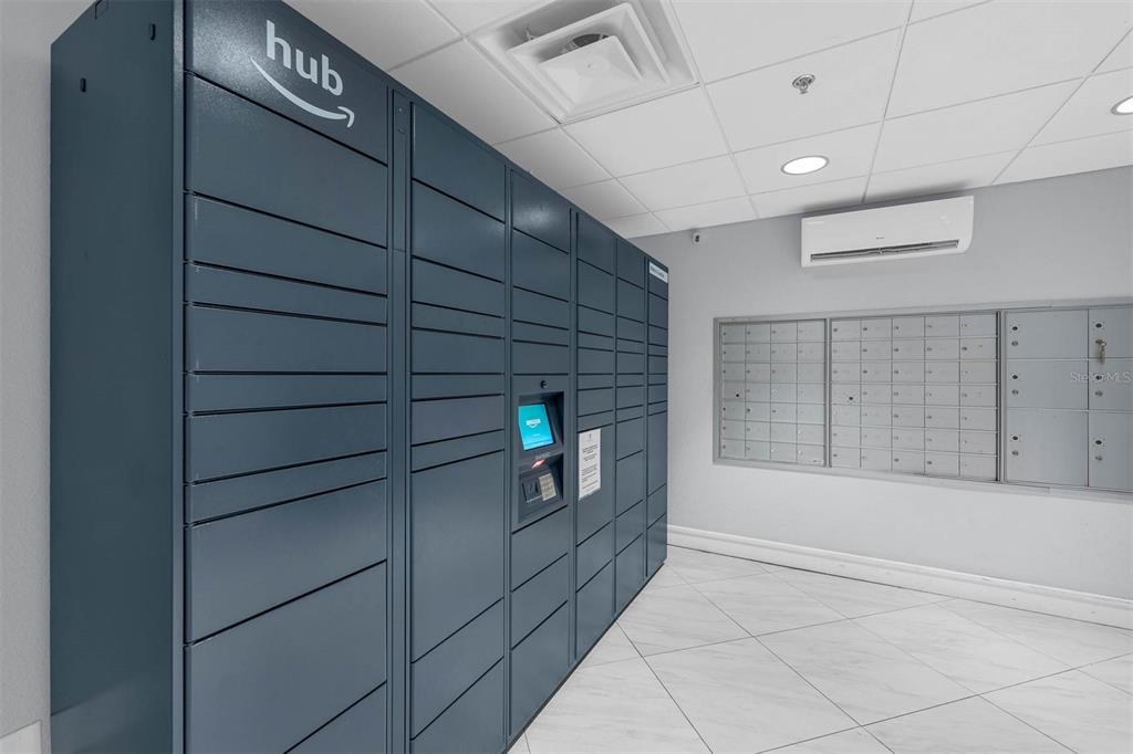 A mailroom features a large blue Amazon Hub locker system and a wall of metal mailboxes — 151 E WASHINGTON STREET UNIT 404, ORLANDO, FL