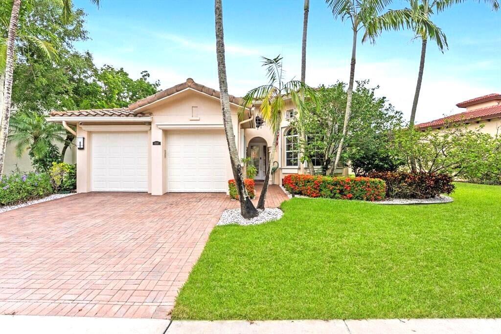 A single-story house with a two-car garage, brick driveway, and palm trees in the front — 8247 NW 107th Terrace, Parkland FL 33076, PARKLAND, FL
