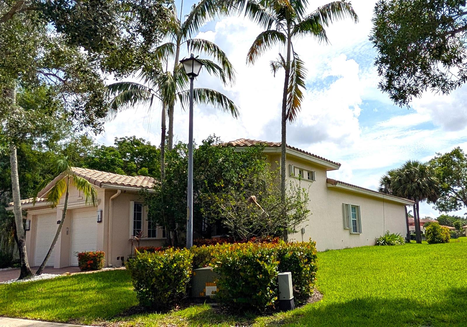 A beige single-story house with a tile roof, palm trees, and a front lawn — 8247 NW 107th Terrace, Parkland FL 33076, PARKLAND, FL
