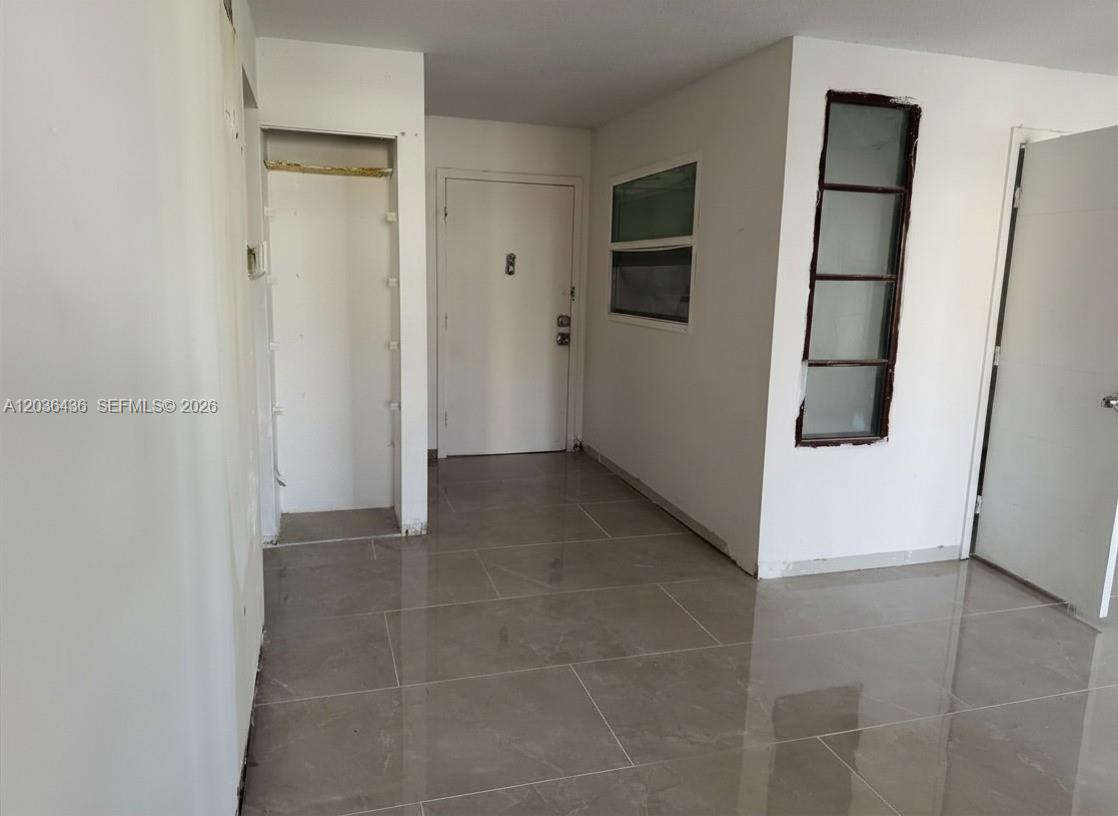 An interior view shows a tiled entryway with a closet, a white door, and windows — 2301 NW 41st Ave # 302, Lauderhill FL 33313, LAUDERHILL, FL