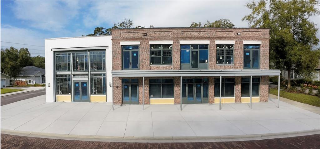 A two-story brick and white stucco commercial building with large glass windows and doors — 186 S MAIN STREET, WINTER GARDEN, FL