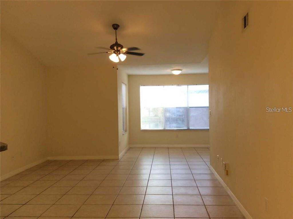 An empty room with beige walls, a ceiling fan, and light-colored tile flooring — 5713 GATLIN AVENUE UNIT 227, ORLANDO, FL