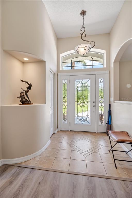 An entryway features a tiled floor, a decorative light fixture, and a curved display niche — 48 BARRING PLACE, PALM COAST, FL