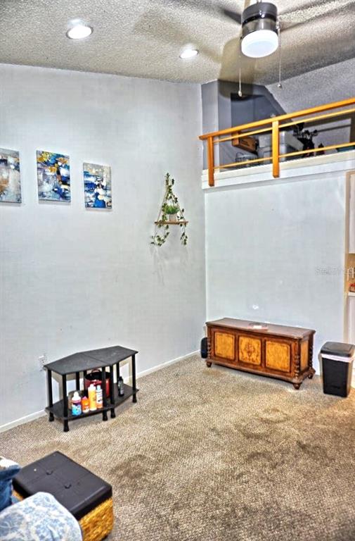 A room with carpeted flooring, a wooden chest, a small shelf, and a loft area — 20857 HAULOVER COVE UNIT B14, LUTZ, FL