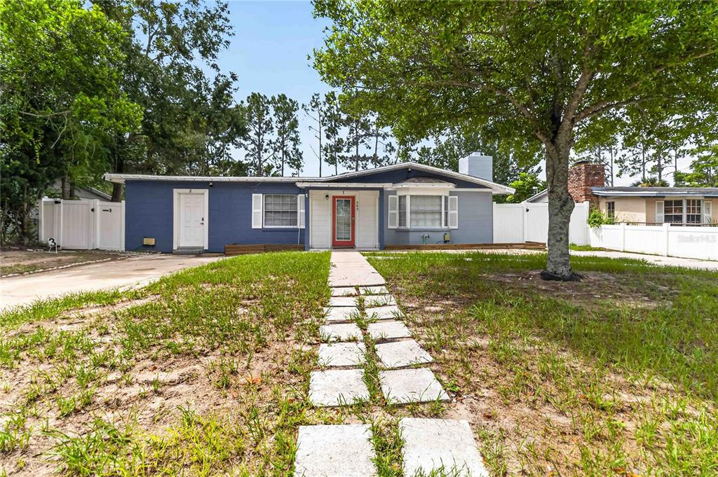 A single-story blue house with a red front door and a stone walkway — 745 HILLVIEW DRIVE, ALTAMONTE SPRINGS, FL